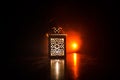 Burning lantern in the dark. Ornamental lantern with burning candle glowing at night. Wth a lot of empty space. Red orange fire ba Royalty Free Stock Photo