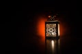 Burning lantern in the dark. Ornamental lantern with burning candle glowing at night. Wth a lot of empty space. Red orange fire ba Royalty Free Stock Photo