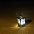 Burning lantern on the seashore. Lamp in the dark