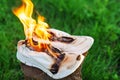 Burning leather sports shoes. Sneakers or gym shoes on fire stand on the Stump.