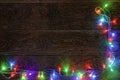 Burning LED garland on a dark wooden background. Preparation for