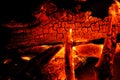 Burning log of wood close-up as abstract background. The hot embers of burning wood log fire. Firewood burning on grill Royalty Free Stock Photo