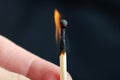 Burning match in hand against a black background. Close-up shot Royalty Free Stock Photo