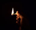 A burning match in his hand. Hand with a burning match in the dark. Close up Royalty Free Stock Photo