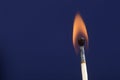 Burning match stick against blue background Royalty Free Stock Photo