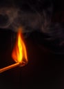 Burning matchstick agains black background Royalty Free Stock Photo