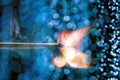 Burning matchstick with blue bokeh