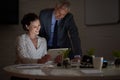 Burning the midnight iol in the office. two colleagues using a digital tablet while working late in an office.