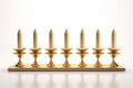 Burning minor candles in a golden candelabrum on a white background