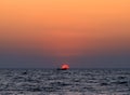 Burning ocean sunset with boat Royalty Free Stock Photo