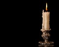 Burning old candle vintage Silver bronze candlestick. Black Background. Royalty Free Stock Photo
