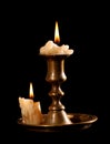 burning old candle vintage bronze candlestick. Isolated Black Background. Royalty Free Stock Photo
