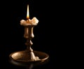 burning old candle vintage bronze candlestick. Isolated Black Background. Royalty Free Stock Photo