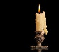 Burning old candle vintage Silver bronze candlestick. Isolated Black Background.