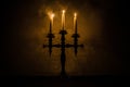 burning old candle vintage wooden candlestick. on dark toned foggy Background. Royalty Free Stock Photo