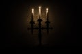 burning old candle vintage wooden candlestick. on dark toned foggy Background. Royalty Free Stock Photo