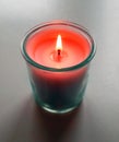 Burning orange candle on white background