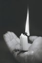 Burning out candle with melting wax on a woman`s palm. Black and white vertical photography Royalty Free Stock Photo