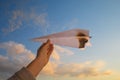 A hand holds a burning paper airplane in the background of the sky. Royalty Free Stock Photo