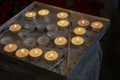 Burning prayer candles inside a catholic church. Lit tea lights. Selective focus Royalty Free Stock Photo