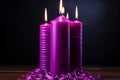 Burning purple candles with ribbons on wooden table, closeup