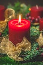 Burning red candle in an advent arrangement with fresh fir branches, first advent Royalty Free Stock Photo