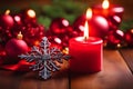 A burning red candle and an array of festive Christmas decorations Royalty Free Stock Photo