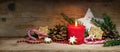 Burning red candle and decoration for Christmas and Advent on rustic wooden planks in panoramic format, copy space Royalty Free Stock Photo