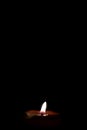 Burning red candle flame with dark background in vertical with area for copy space Royalty Free Stock Photo