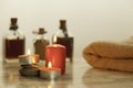 Burning red candles , bath oils on marble table and grey background Royalty Free Stock Photo