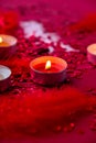 Burning red candles on confetti sequinned background with feathers. Saint Valentines Day and Christmas background . Holidays Royalty Free Stock Photo