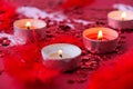 Burning red candles on confetti sequinned background with feathers. Saint Valentines Day and Christmas background . Holidays Royalty Free Stock Photo