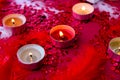 Burning red candles on confetti sequinned background with feathers. Saint Valentines Day and Christmas background . Holidays Royalty Free Stock Photo