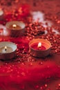 Burning red candles on confetti sequinned background with feathers. Saint Valentines Day and Christmas background . Holidays Royalty Free Stock Photo