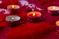 Burning red candles on confetti sequinned background with feathers. Saint Valentines Day and Christmas background . Holidays