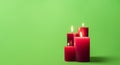 Lit candles isolated on a green background. Group of red candles