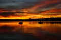 burning red sunset on lake Ammersee with sailing boats resting on the water (Herrsching in Germany)