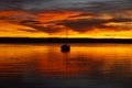 burning red sunset on lake Ammersee with sailing boats on the water (Herrsching on Ammersee in Germany)