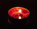 Burning red tealight candle Royalty Free Stock Photo