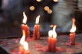 Burning red wax candles in a Buddhist temple Royalty Free Stock Photo