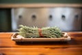 a burning sage bundle on a rustic wooden tray