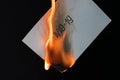 Burning sheet of paper with the text COVID-19 on a black background