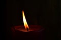 Burning single red candle with dancing flame on the dark background Royalty Free Stock Photo