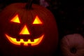 Burning smile carved mask of halloween pumpkins terrifying face out of the dark