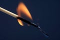 Burning and Smoking wooden match on dark background