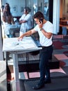 Burning some calories while making some deals. a young businessman talking on a cellphone and going through paperwork