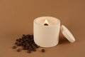 Burning soy candle and coffee beans on brown background Royalty Free Stock Photo