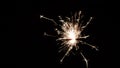 Burning sparkler on black background.