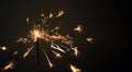 Burning sparkler on dark background