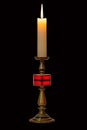 Burning stearin candle on a bronze candlestick Royalty Free Stock Photo